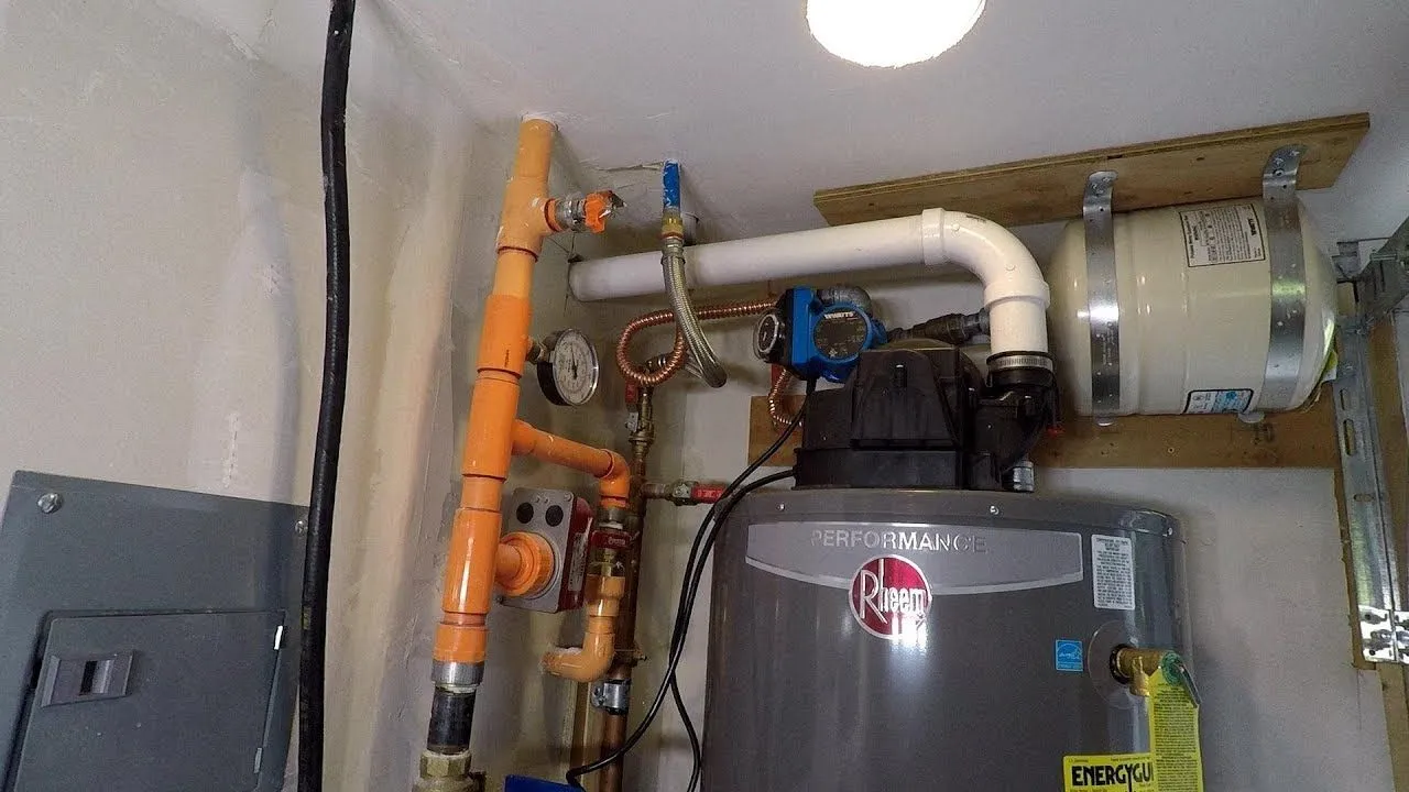 Rheem power vent gas water heater installed with PVC vent piping and a gas line